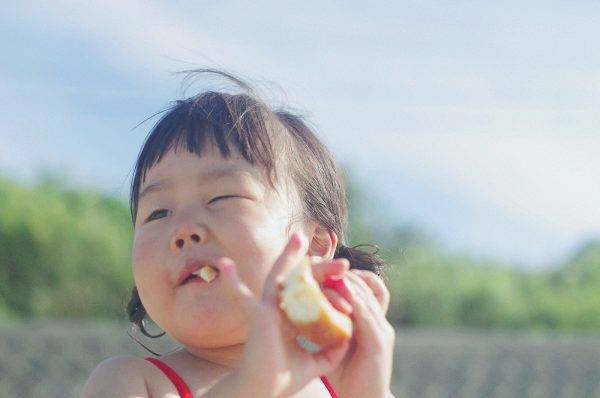Close-up Photography Of A Girl Eating Bread