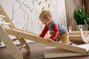 Happy Toddler Climbing Up a Wooden Ladder